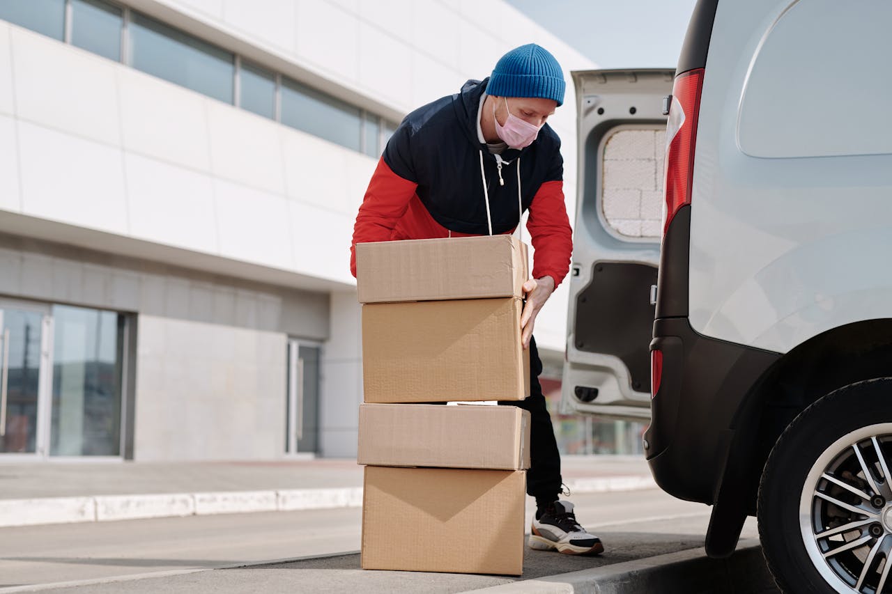 Crafting Captivating Headlines: Your awesome post title goes here Delivery worker wearing a face mask loads boxes into a van, reflecting pandemic precautions.