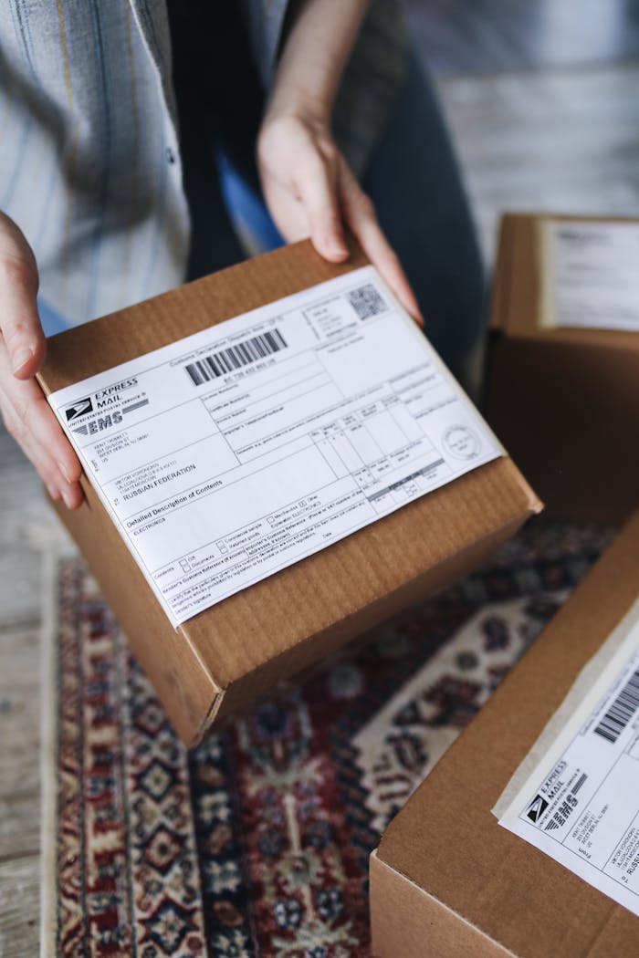 heros-img Close-up of hands holding a package with a visible shipping label, perfect for delivery themes.