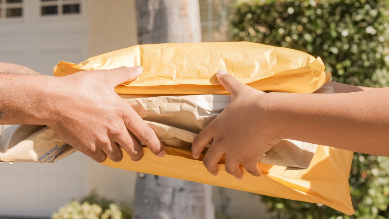 The Art of Drawing Readers In: Your attractive post title goes here Close-up of two hands exchanging packages, symbolizing delivery and communication.
